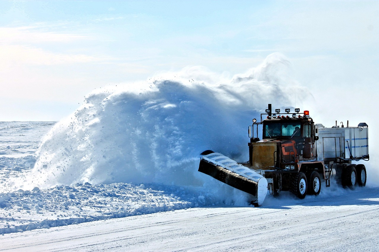 Snow plow kicking up snow