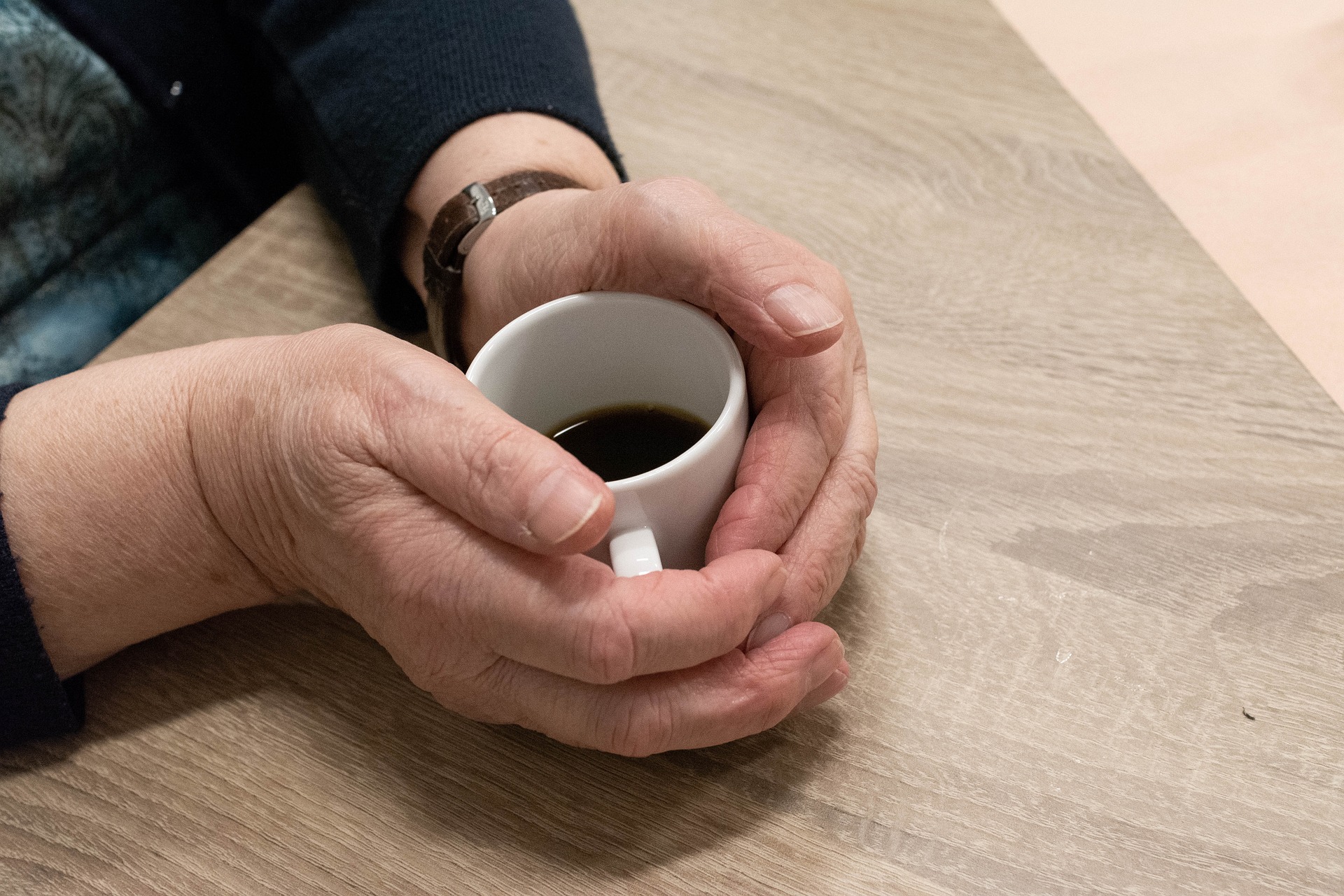 Hands cupping a mug of coffee.