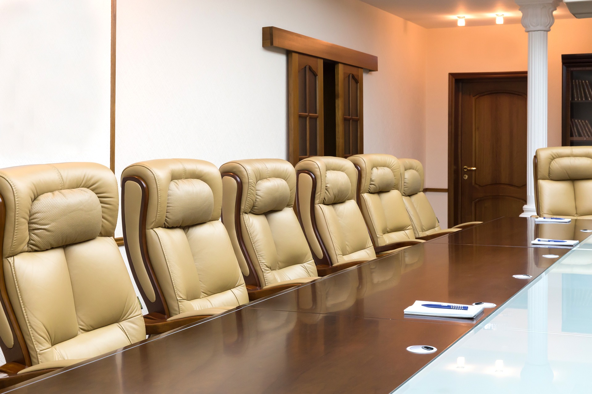 Empty office chairs along a oblong table.