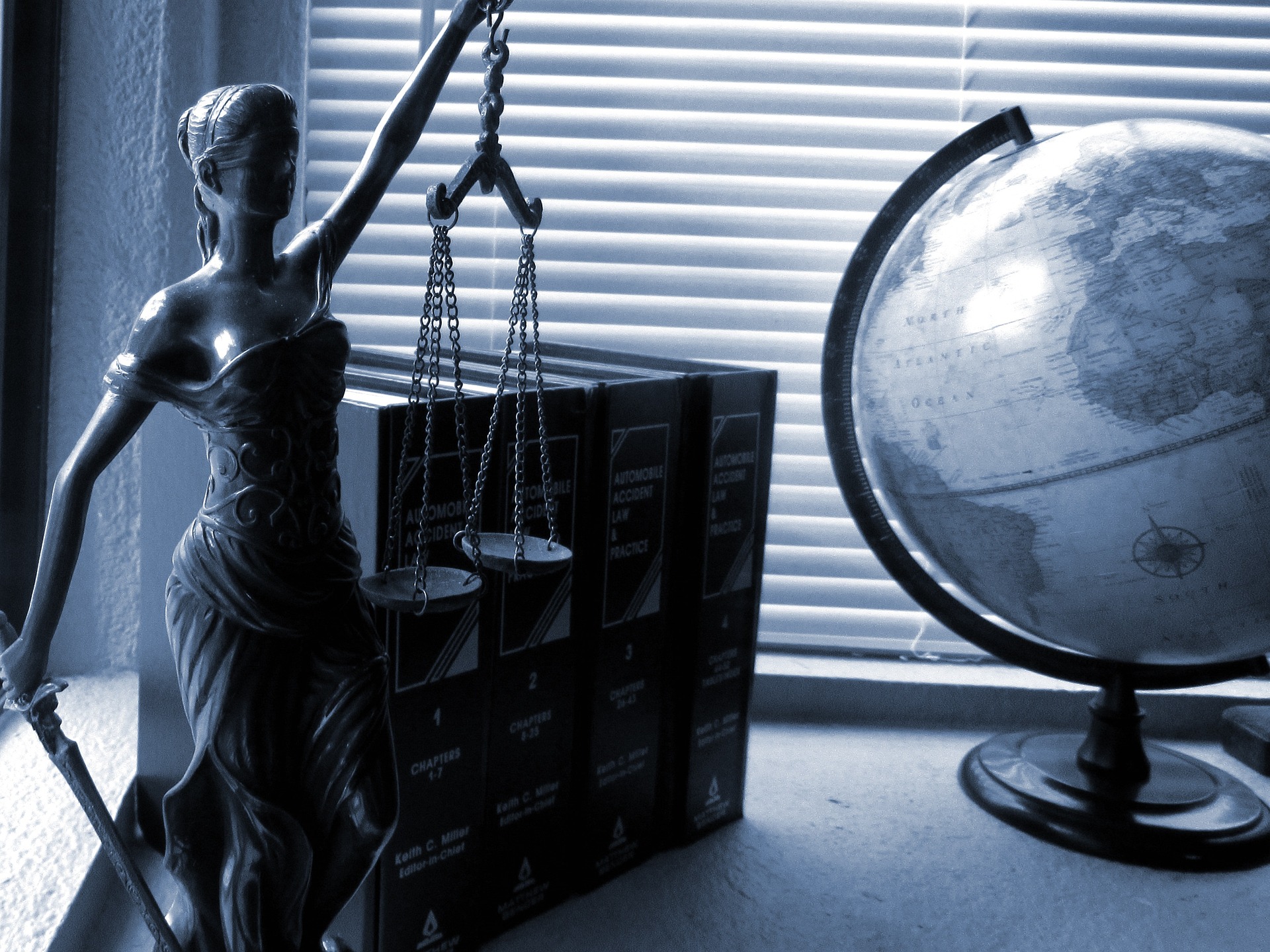 Lady Justice next to books and a globe.