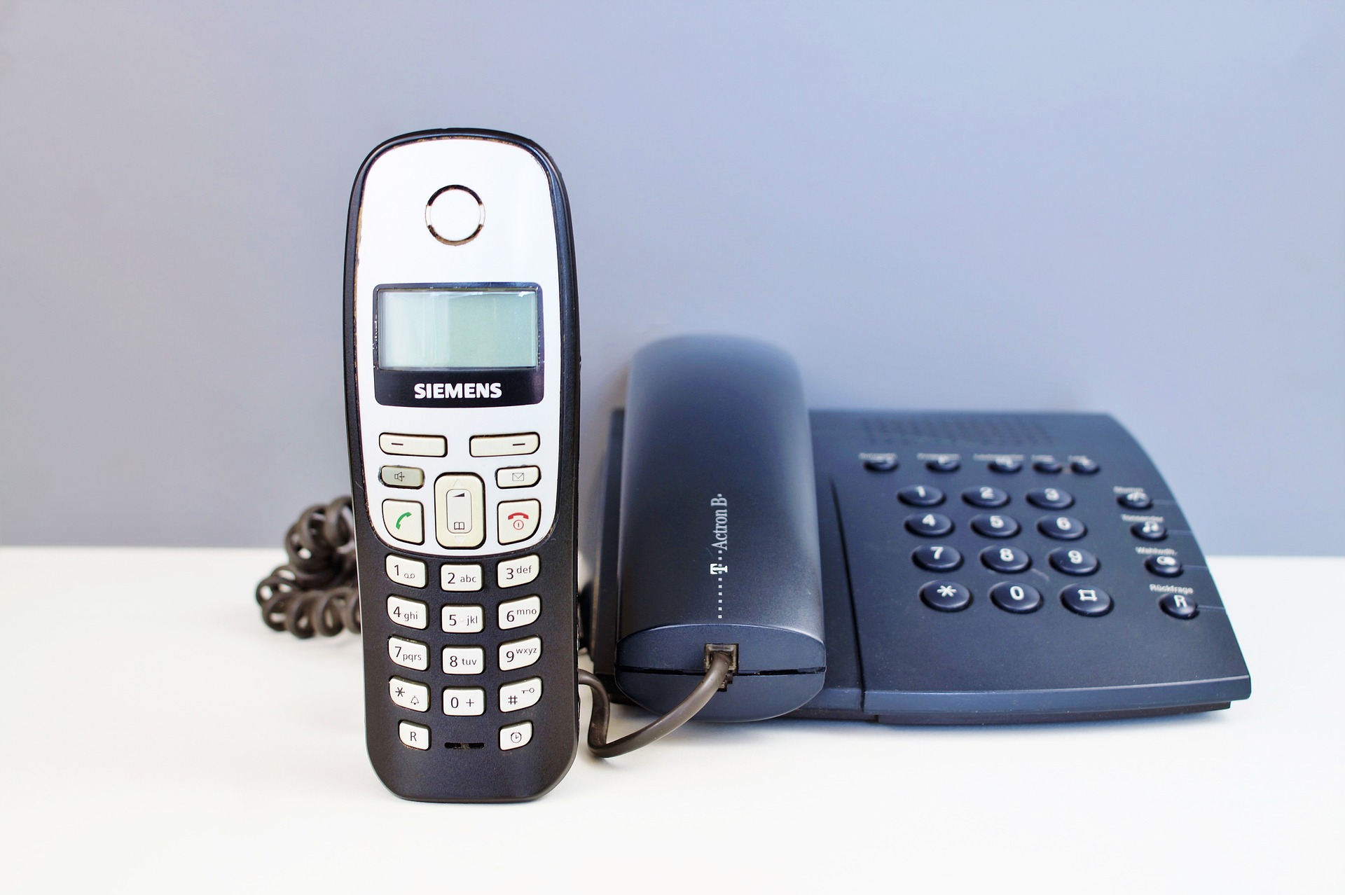 Two dial-up telephones set beside each other.